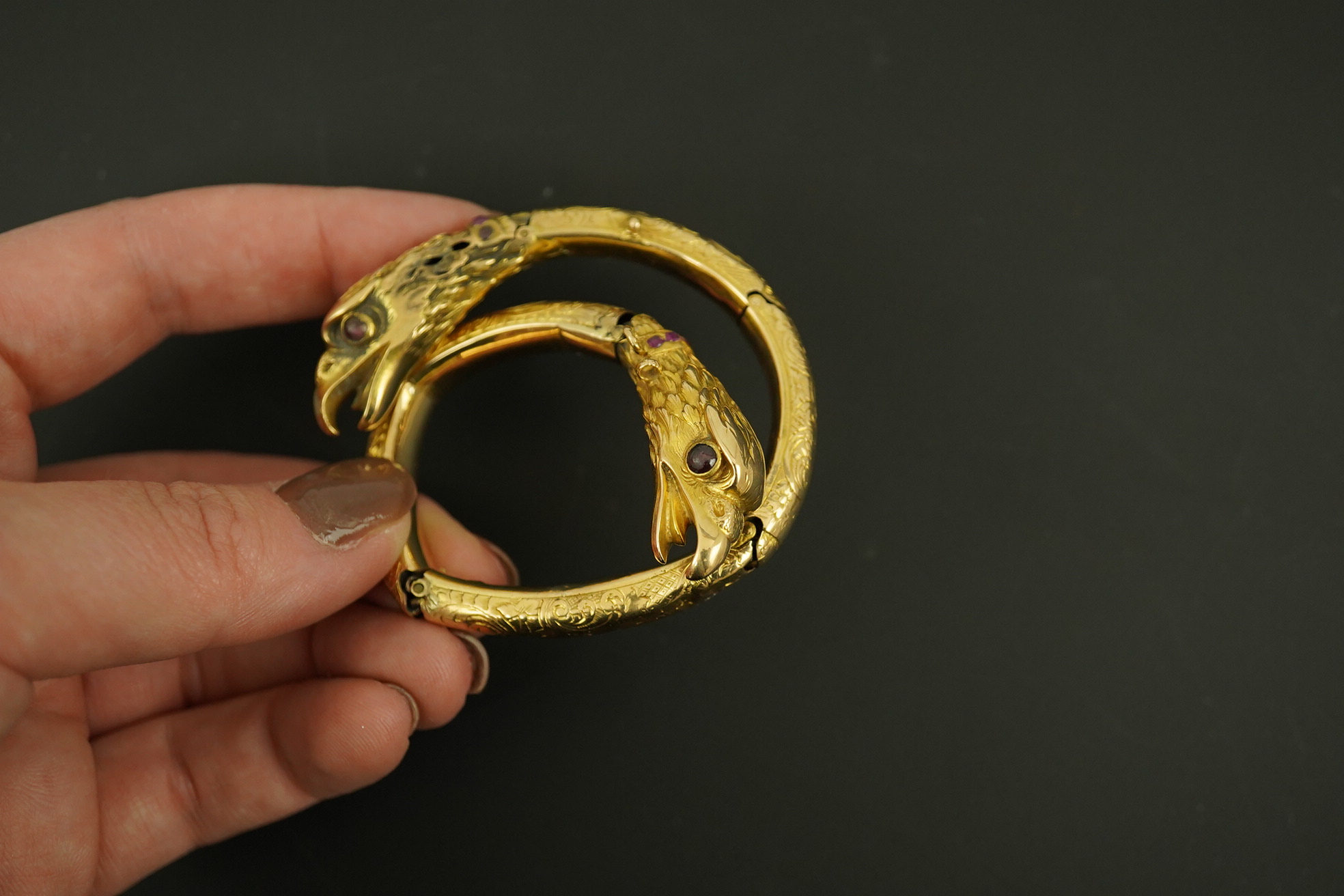 An antique Russian? engraved gold, garnet and ruby cluster set double headed eagle open hinged bracelet